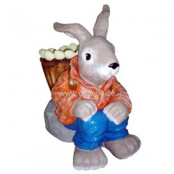 Tier - Figur Osterhase mit Eier - Korb sitzt auf Stein